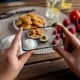 telefono che fa una foto ad un piatto con riso, pomodori e nuggets