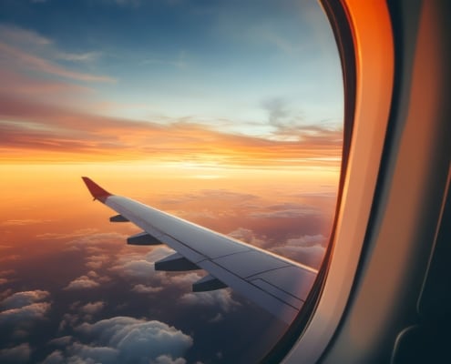 oblò di un aereo sopra le nuvole al tramonto