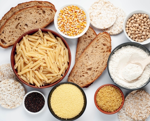 vista dall'alto di vari alimenti contenenti glutine tre cui pane e pasta